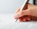 Frauenhand mit Stift und Formular - Russland-Urlauber müssen sich nach der Einreise innerhalb von einem Tag anmelden.