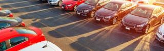 Autos auf Parkplatz - Wer sein Auto während des 14-tägigen Sommerurlaubs direkt am Flughafen abstellt, muss mit bis zu 490 Euro Parkgebühren rechnen.