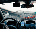 Smartphone mit Halterung im Auto - Wegen der Sperrung des Gotthardtunnels im Sommer sollten Autofahrer Ausweichrouten nutzen.